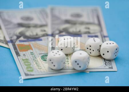 Game dice and hundred dollar bills on blue background. Board game, gambling, casino concept Stock Photo