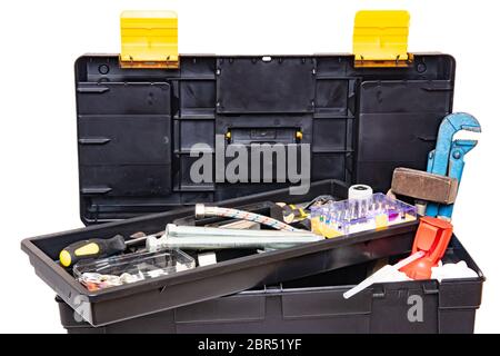 Tool box isolated. Black plastic tool kit box with assorted tools and with various nails, screws, fasteners as well as dowels isolated on a white back Stock Photo