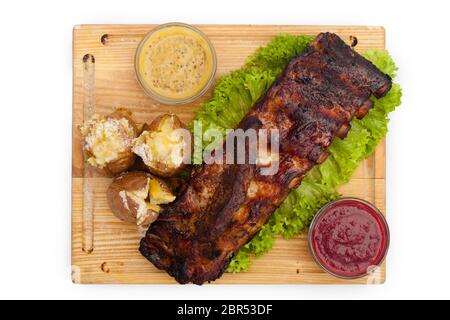 Fried meat, herbs, sauces, potatoes, on a wooden board Stock Photo