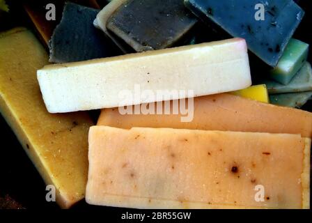 Quadrangular pieces of soap of various colors displayed on newsprint paper grouped by colors: brown-white-red-orange-yellow-green. Stock Photo
