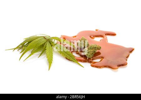 Marijuana extract shatter with marijuana leafs, isolated on white background. Stock Photo