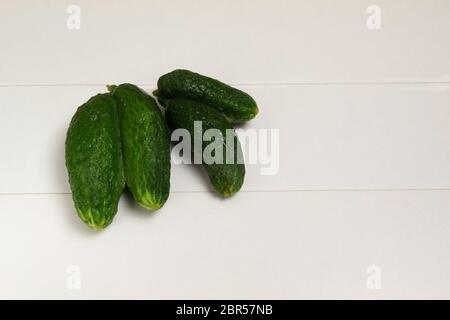Ugly Siamese-twin cucumbers on a white background. Copy space. Stock Photo