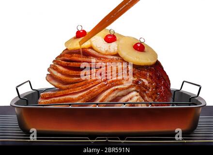 Basting Holiday spiral sliced ham with juices Stock Photo