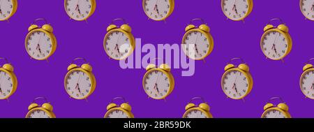 Seamless Pattern made with yellow clock image on purple paper background. Stock Photo
