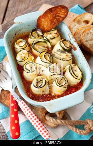 Rolled zucchini filled with cream cheese, oven baked Stock Photo