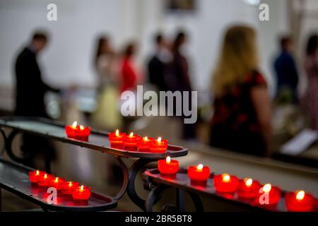 Wedding marriage ceremony in church. Burning candles in the church during the wedding ceremony. Christian church decorated from candles for wedding ma Stock Photo