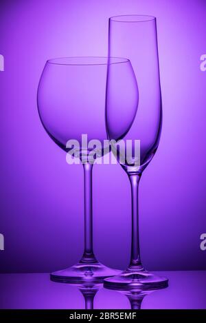 Two empty wineglasses on a purple background Stock Photo