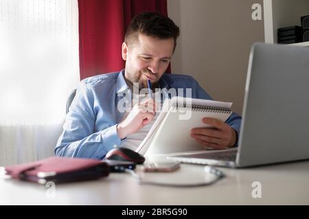 Young caucasian man working from home reading documents during isolation Stock Photo