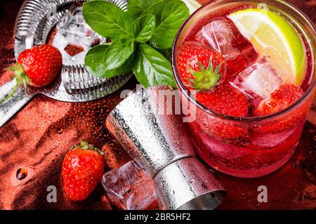 Red drink with strawberry, mint leaves, ice. Cocktail with campari ...