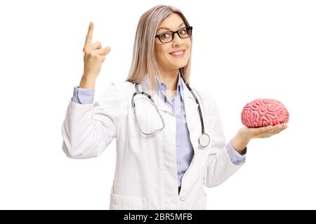 Female doctor holding a brain model and pointing up isolated on white background Stock Photo