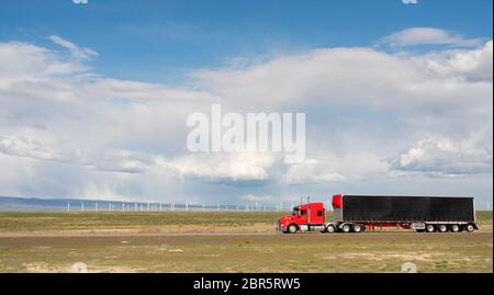Red big rig semit truck with black cargo trailer on a Utah Highway Stock Photo
