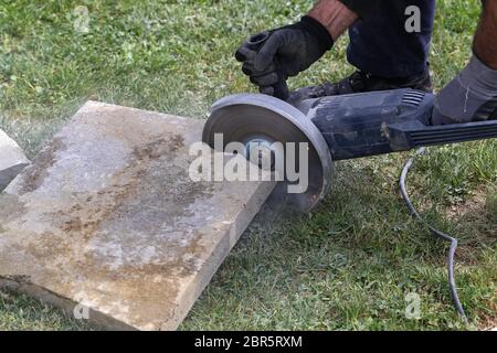 Industrial construction worker using a professional angle grinder Stock Photo