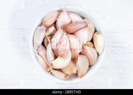 Garlic cloves from above bowl wooden board wood Stock Photo