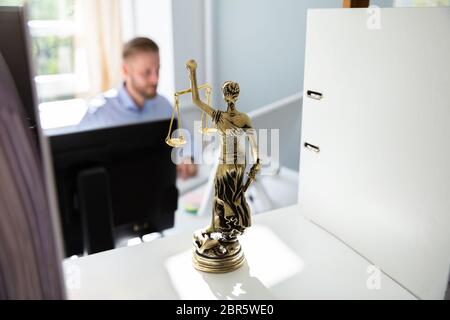 Justice Statue On Shelf And Lawyer Working In Office At background Stock Photo