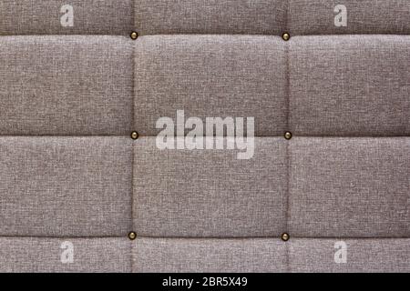 Brown fabric texture closeup with decorative stitching from threads. Background from decoratively trimmed fabric. Stock Photo