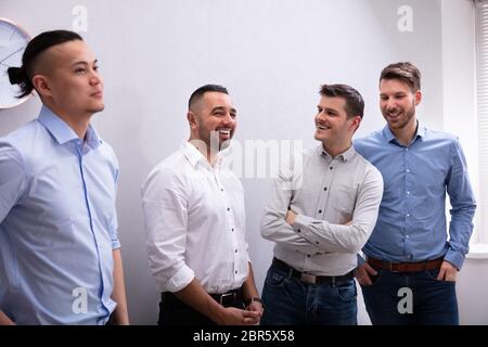 Diverse Group Of Smiling Businessmen Talking Together Stock Photo