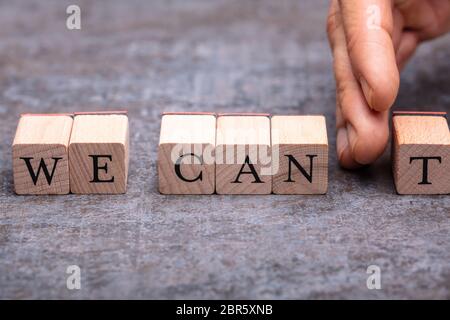 Close-up Of Human's Hand Breaking Can't Word Over Concrete Surface Stock Photo