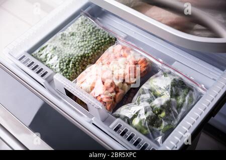 An Overhead View Of Frozen Vegetables In Plastic Bag Over Refrigerator Tray Stock Photo