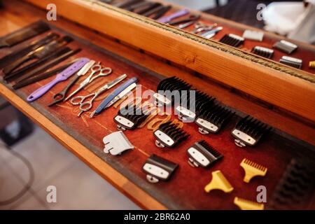 Trimmer nozzles are laid out on a wooden table in a barbershop. Professional barber tool kit. Hairdressing equipment Stock Photo