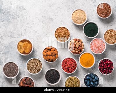 Various superfoods in smal bowl gray concrete background. Superfood as chia, spirulina, raw cocoa bean, goji, hemp, quinoa, bee pollen, black sesame, Stock Photo