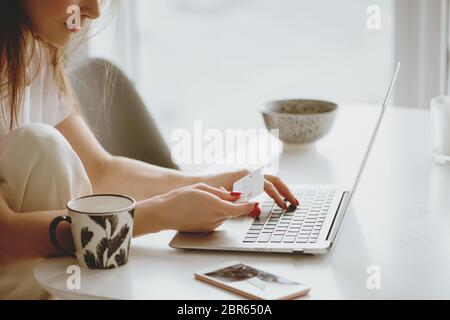 Partial view of woman inputting card information while shopping online. Stock Photo
