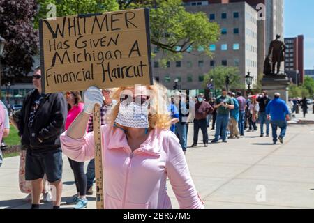 Lansing, Michigan, USA. 20th May, 2020. People wait in line for free haircuts on the lawn of the Michigan State Capitol. The event was a protest of Governor Gretchen Whitmer's emergency orders which keep many businesses closed during the coronavirus pandemic. The protest, called Operation Haircut, was organized by the Michigan Conservative Coalition. Credit: Jim West/Alamy Live News Stock Photo