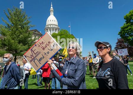 Lansing, Michigan, USA. 20th May, 2020. Barbers give free haircuts on the lawn of the Michigan State Capitol to protest Governor Gretchen Whitmer's emergency orders which keep many businesses closed during the coronavirus pandemic. The protest, called Operation Haircut, was organized by the Michigan Conservative Coalition. Credit: Jim West/Alamy Live News Stock Photo