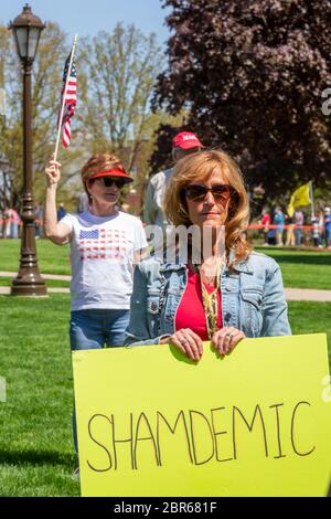 Lansing, Michigan, USA. 20th May, 2020. Barbers give free haircuts on the lawn of the Michigan State Capitol to protest Governor Gretchen Whitmer's emergency orders which keep many businesses closed during the coronavirus pandemic. The protest, called Operation Haircut, was organized by the Michigan Conservative Coalition. Credit: Jim West/Alamy Live News Stock Photo