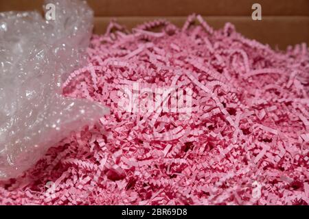 Close up of pink packing paper and bubble wrap in a box Stock Photo