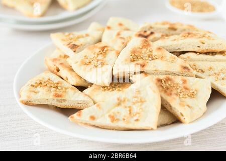 Homemade crispy pita chips with roasted sesame seeds and sea salt, photographed with natural light (Selective Focus, Focus in the middle of the image) Stock Photo