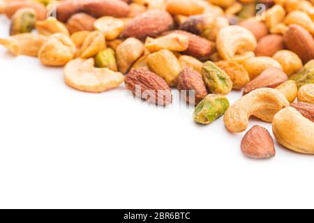 Spicy flavoured nuts. Mix of nuts isolated on white background. Stock Photo