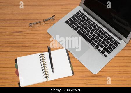 Desk with open notepad, pen, eye glasses, nicely placed on office table. Top view with copy space. Business still life concept with office stuff on ta Stock Photo