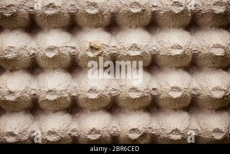 Top view surface sheet of empty cardboard egg crate or eggs carton box made of foam type brown color packing sheet. Old vintage look. Close up. Natura Stock Photo