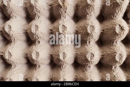 Top view surface sheet of empty cardboard egg crate or eggs carton box made of foam type brown color packing sheet. Old vintage look. Close up. Natura Stock Photo