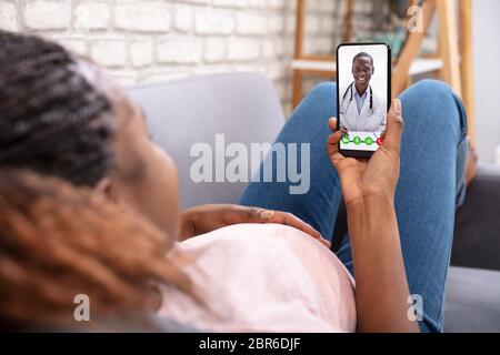Close-up Of Pregnant Woman Video Calling Her Doctor On Mobilephone Stock Photo