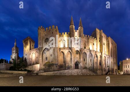 Palace of the Popes, once a fortress and palace, one of the largest and most important medieval Gothic buildings in Europe, during evening blue hour, Stock Photo
