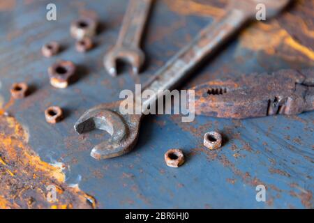 Old rusty wrench over battered metal table rough style. Wrenches top view for construction, industrial, electrician concept design Stock Photo