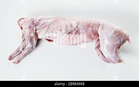 Skinned and cleaned carcass of a wild rabbit ready for roasting for a gourmet venison meal lying on white with copy space Stock Photo