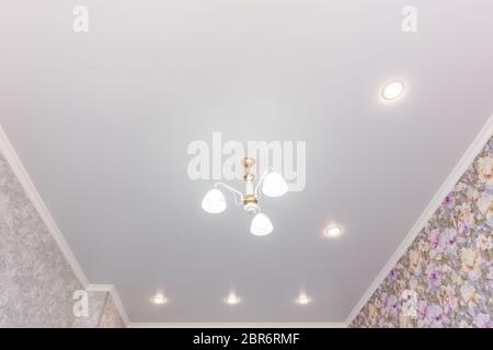 Stretch ceiling in the room with a chandelier and spotlights Stock Photo