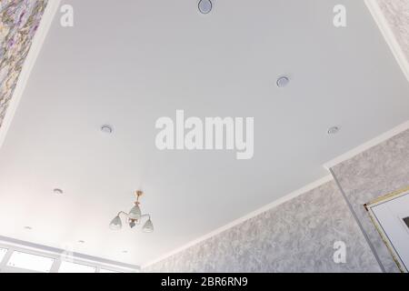 Stretch ceiling in a room with a chandelier and spotlights, with natural light Stock Photo