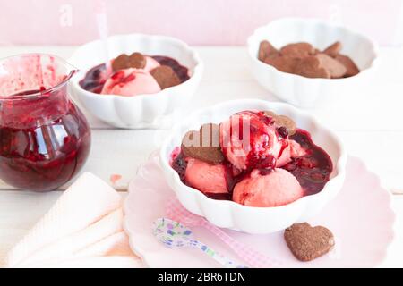 Cup of raspberry ice cream with a fruity sauce Stock Photo