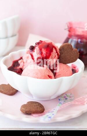 Cup of raspberry ice cream with a fruity sauce Stock Photo