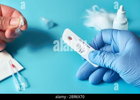 Express COVID-19 test for IgM and IgG antibodies to novel coronavirus SARS-CoV-2, Covid-19. Nurse hand in glove with positive test. Patient fingers wi Stock Photo