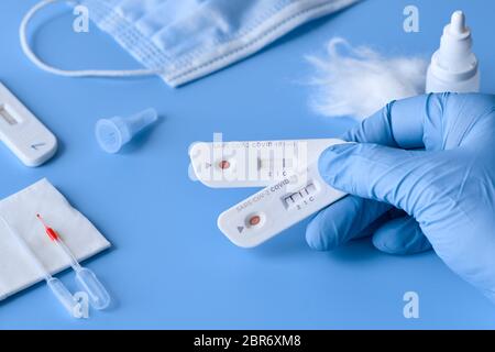 Express COVID-19 test for IgM and IgG antibodies to novel corona virus SARS-CoV-2, Covid-19. Nurse or medtech hand in glove with positive and negative Stock Photo