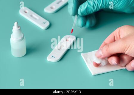 Express COVID-19 test for IgM and IgG antibodies to novel coronavirus SARS-CoV-2, Covid-19. Nurse hand in glove applies blood to the test with pipette Stock Photo