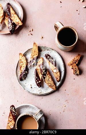 Chocolate dipped hazelnut biscotti with a mug of black coffee. Stock Photo