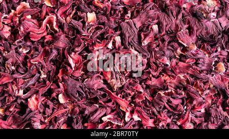 Dry red herbal hibiscus karkade leaf tea as background. Stock Photo