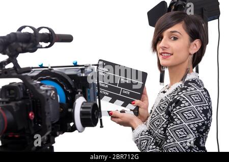 a young woman holding a clapboard. video camera, on the white background Stock Photo