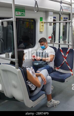 Passengers in Athens metro wearing protective masks and using half of the seats as instructed by the Greek Government due to the coronavirus outbreak Stock Photo