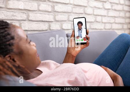 Close-up Of Pregnant Woman Video Calling Her Doctor On Mobilephone Stock Photo